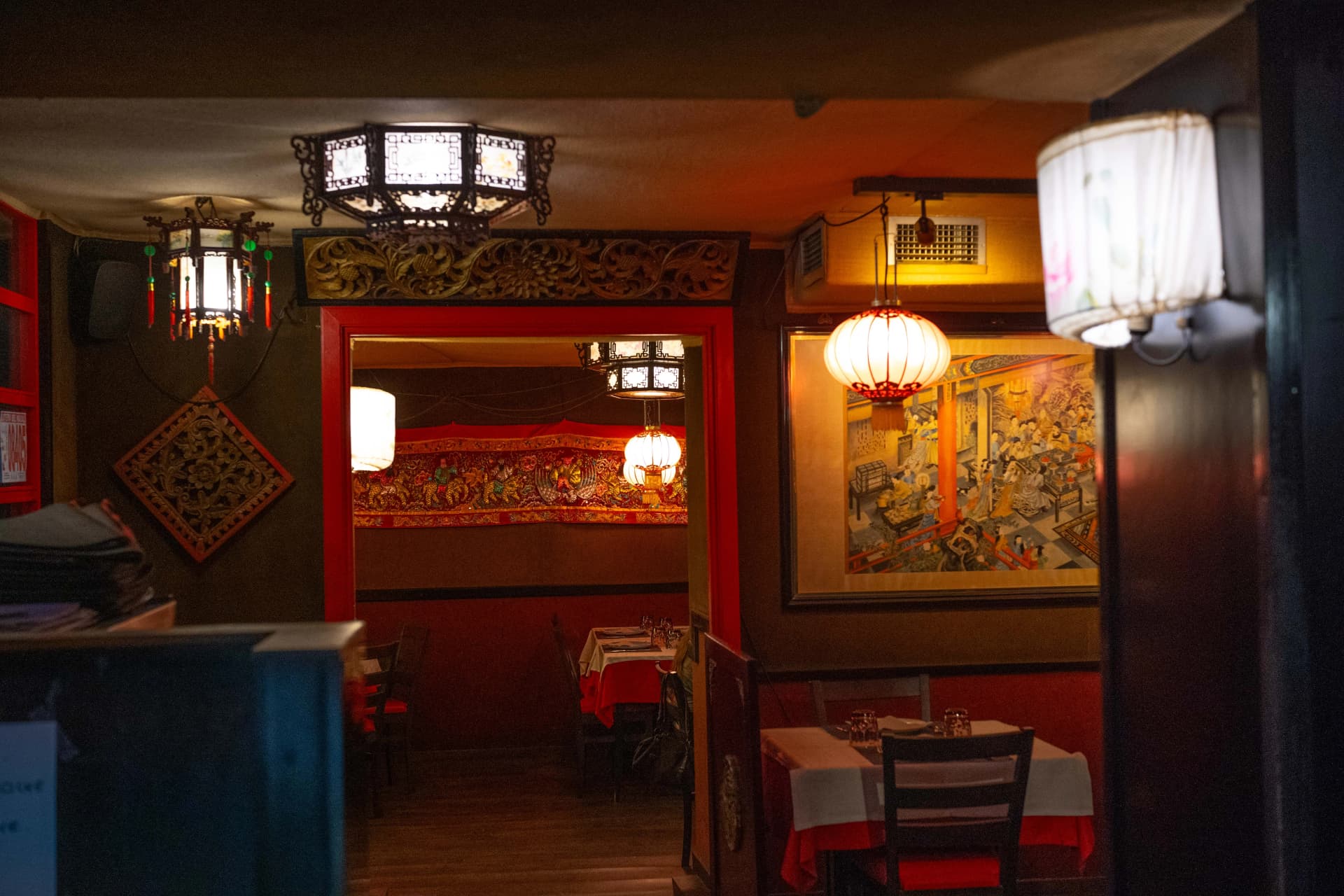 Comedor con decoración china tradicional, mesas vestidas con manteles rojos y blancos